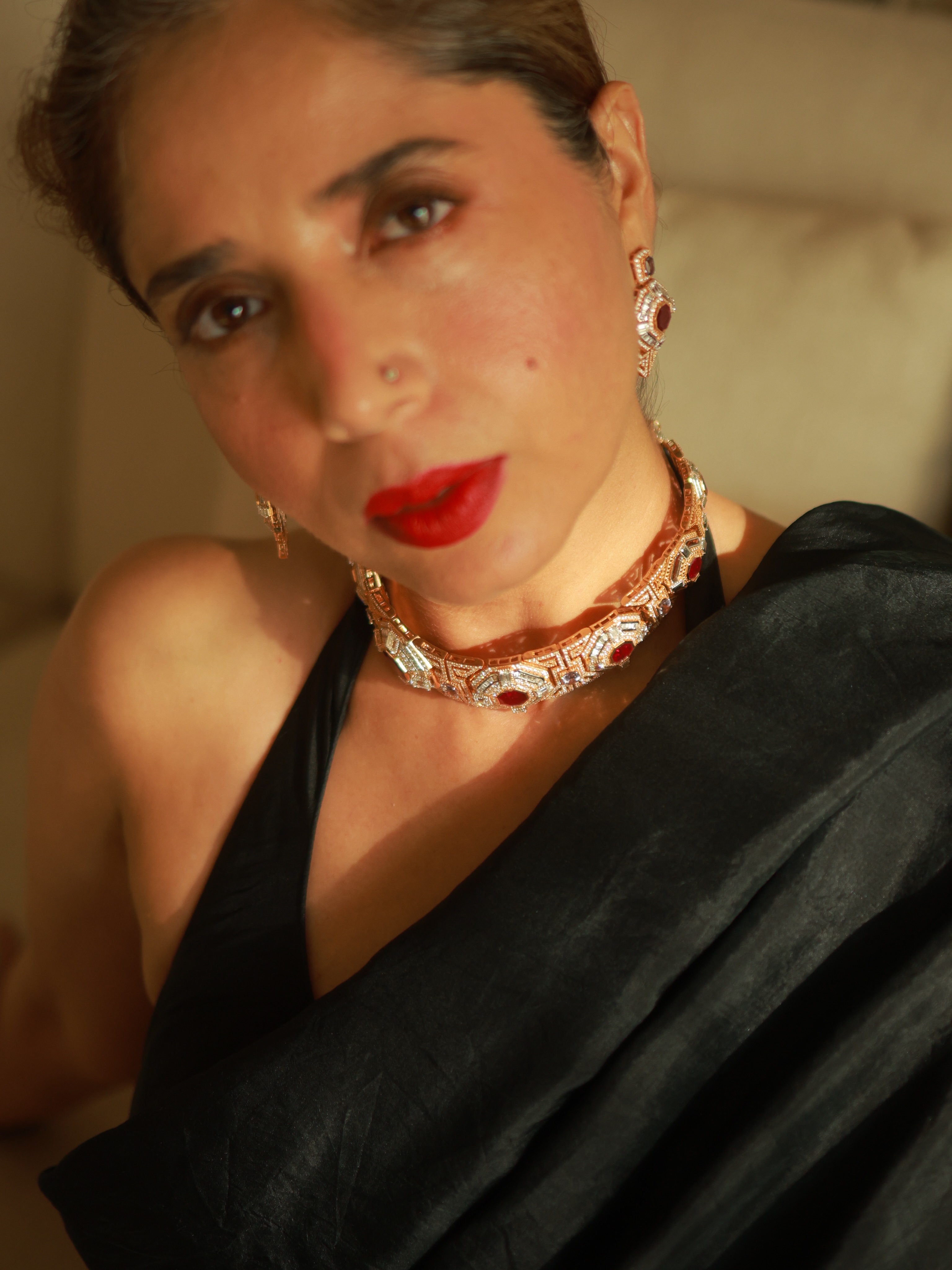 Aiana in a black saree with a bold red lip and a ruby-and-diamond statement choker
